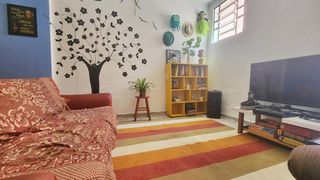 una sala de estar con sofá y un árbol en la pared en Red Monkey Hostel Barra Funda, en São Paulo