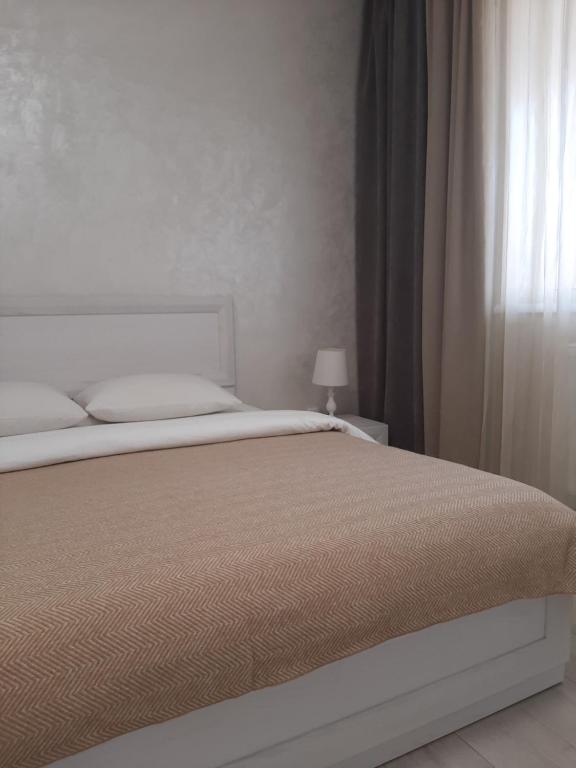 een wit bed in een slaapkamer met een raam bij LUXURY apartment in the City Center with a terrace in Mukacheve