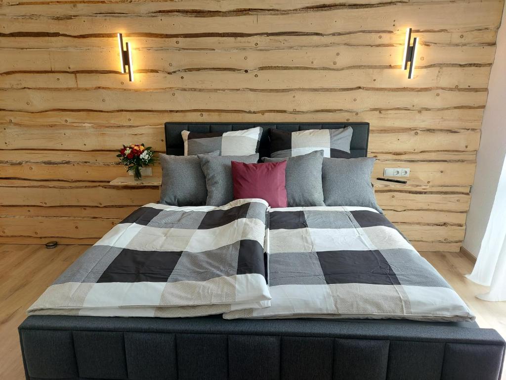 1 dormitorio con 1 cama con pared de madera en Premium Vulkaneifel Chalet, en Lutzerath
