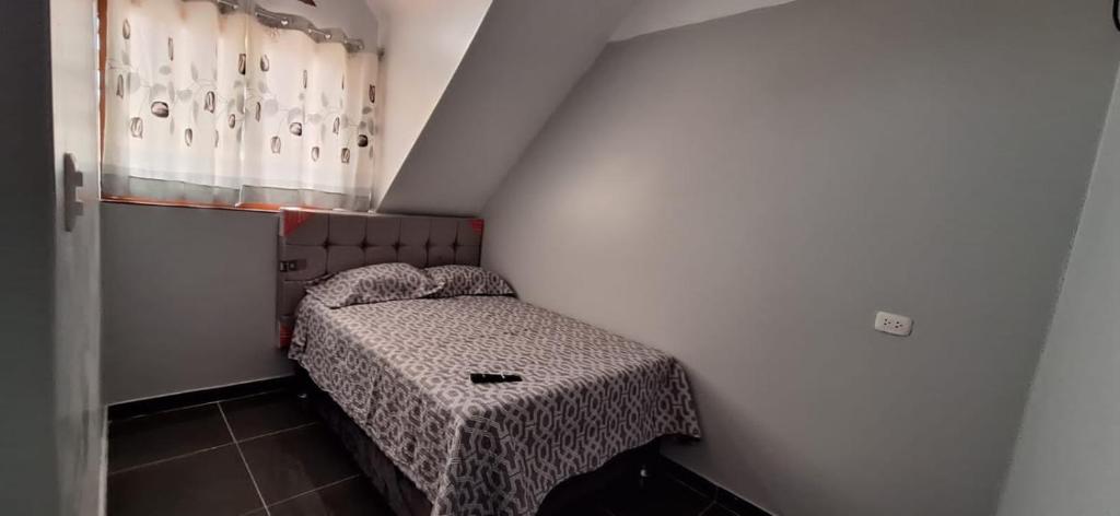 Dormitorio pequeño con cama esquinera en Hospedaje dominguez, en Oxapampa