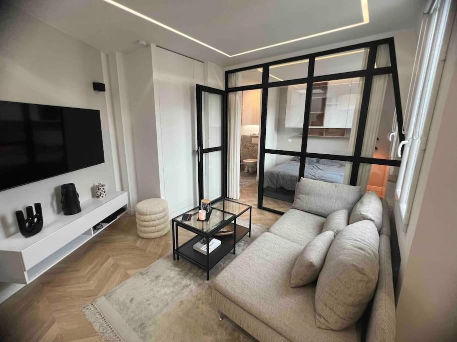 a living room with a couch and a tv at Appartement Malesherbes Paris in Paris