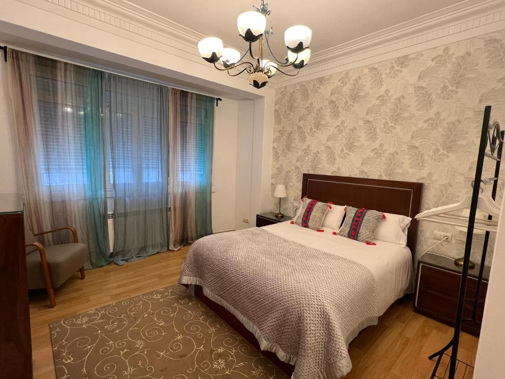 a bedroom with a bed and a chandelier at Céntrico Apartamento in A Coruña
