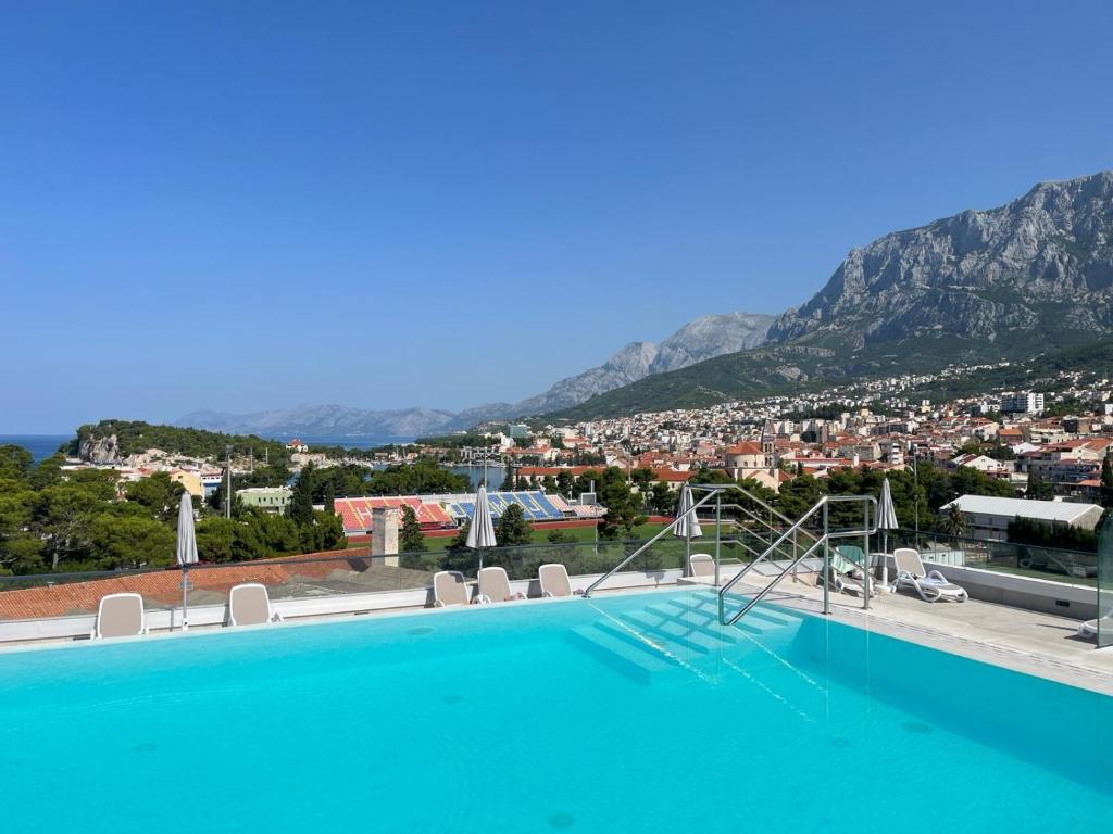 a swimming pool with a view of a city at Uzelac apartment with pool in Makarska