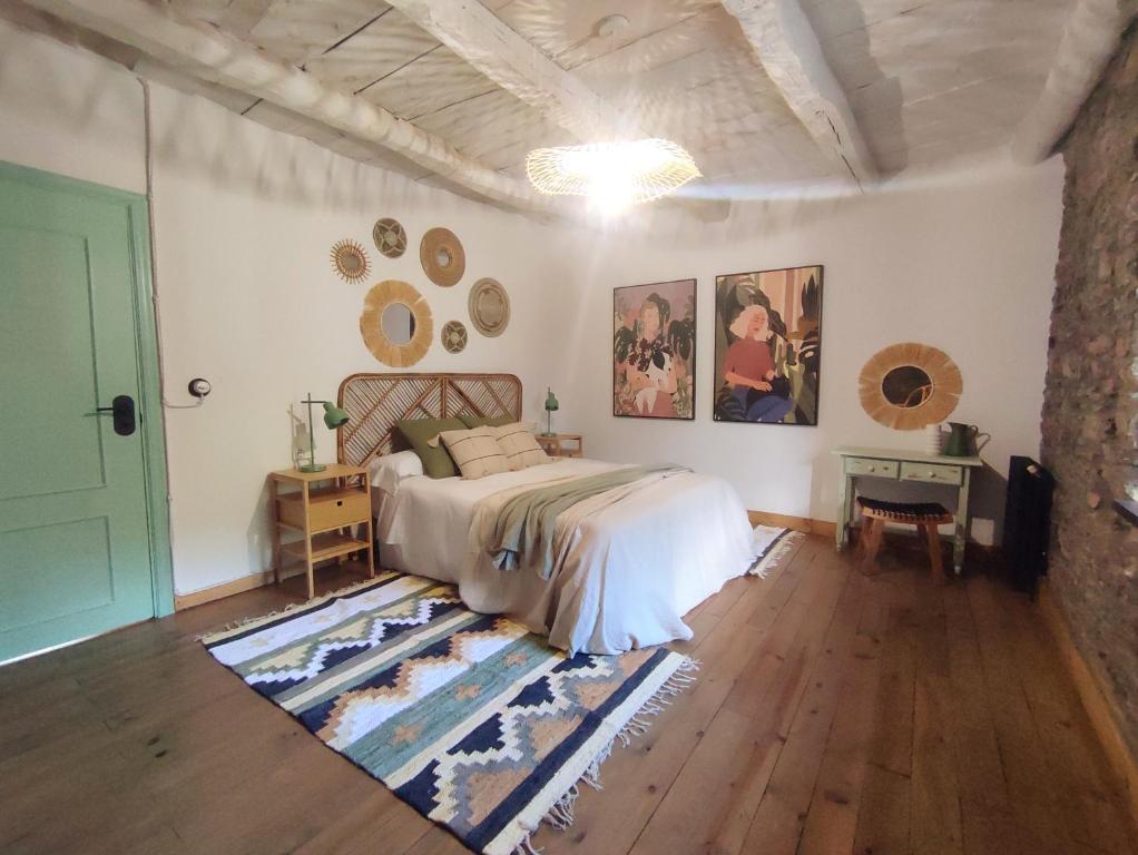 um quarto com uma cama, uma mesa e uma porta em La Escondida em Caboalles de Abajo
