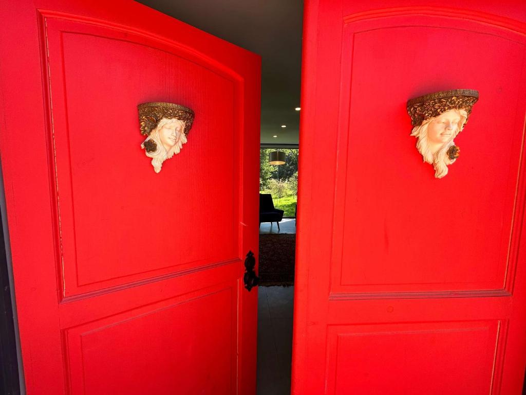 Una porta rossa con una testa dentro. di Casa Melipillán - Melipilla a Melipilla