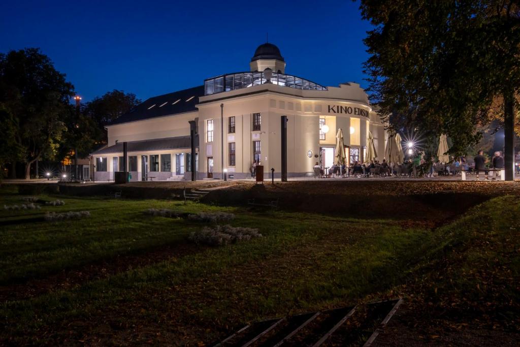 a large white building with people sitting outside at night at Centar 1 in Karlovac