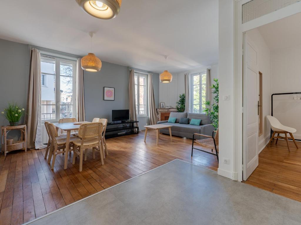 un salon avec une table et un canapé dans l'établissement Le Spacieux , 7 personnes, 6 lits, PARKING, proche LYON PARTDIEU, à Villeurbanne