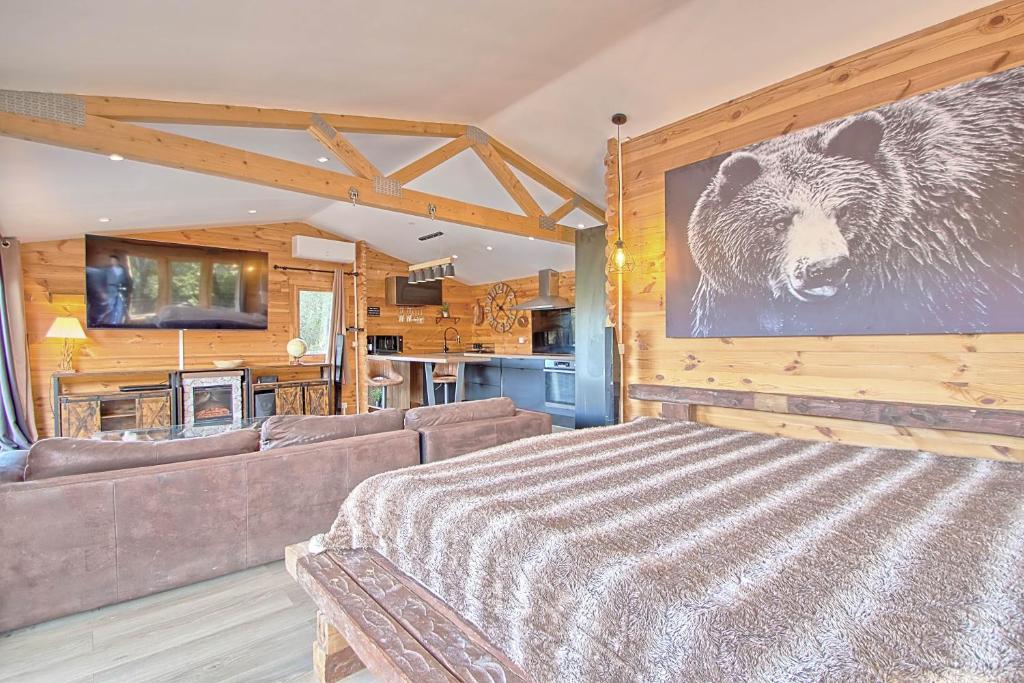 - un salon avec un canapé et un ours sur le mur dans l'établissement romantique cabane perchée avec spa vue panoramique Le Mas des Faraches, à Solliès-Toucas