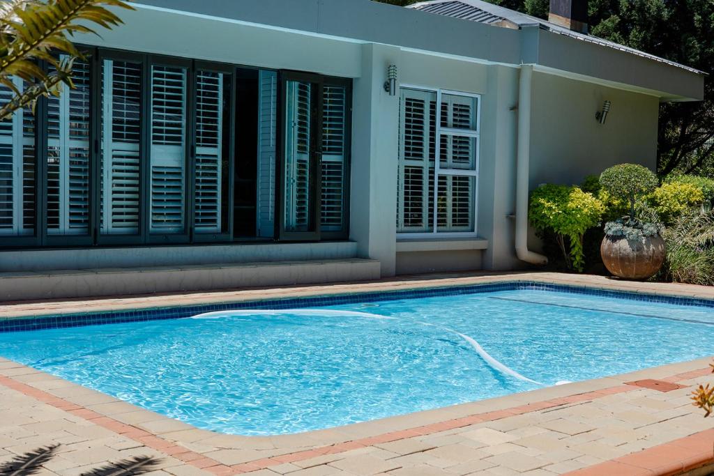 a swimming pool in front of a house at Tristan's Place Guest House in Klerksdorp