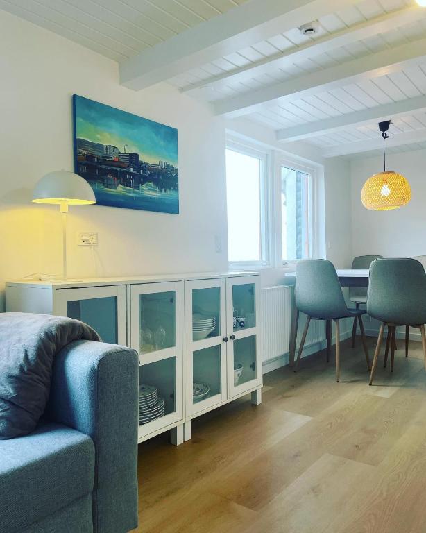 uma sala de estar com uma mesa e um sofá azul em Kirkjatún em Miðvágur