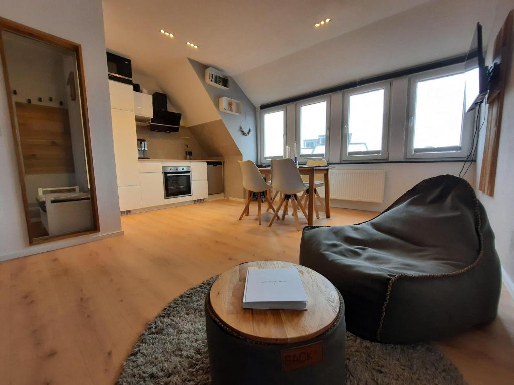 een woonkamer met een bank en een tafel met een laptop bij Moewennest-by-DeJu-Norderney in Norderney