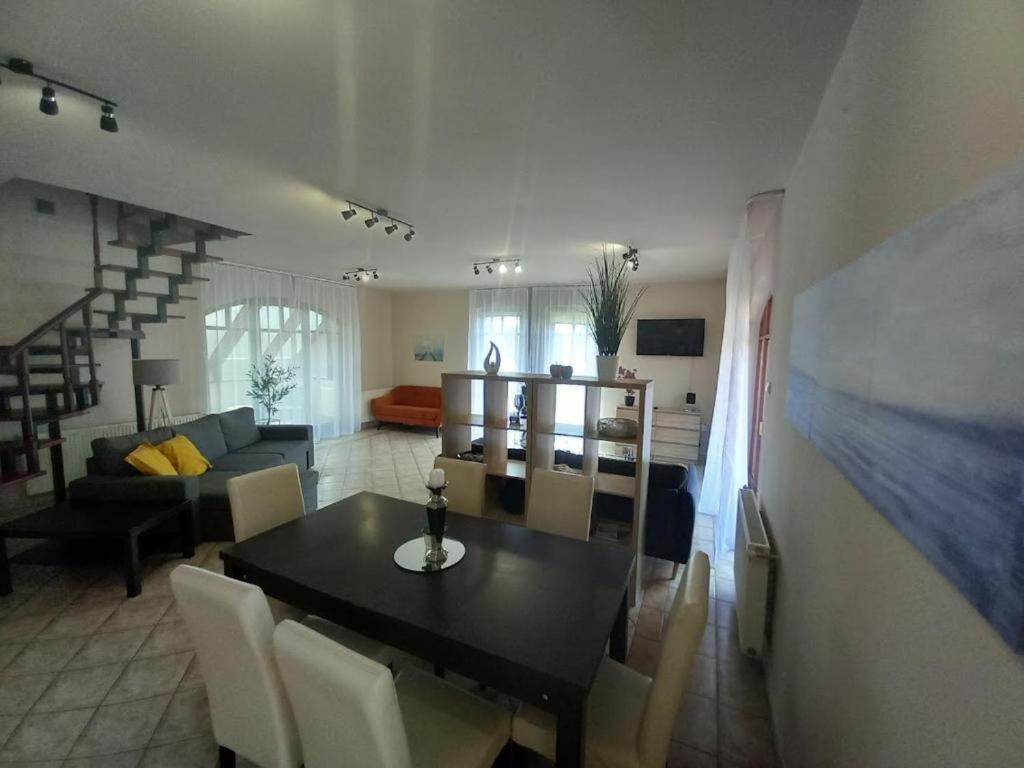 ein Esszimmer und ein Wohnzimmer mit einem Tisch und Stühlen in der Unterkunft Lujza Apartman Gödöllő in Gödöllő