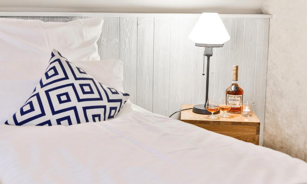 um quarto com uma cama com uma garrafa de vinho e um candeeiro em Hotel & Restaurant Utspann Schafflund em Schafflund