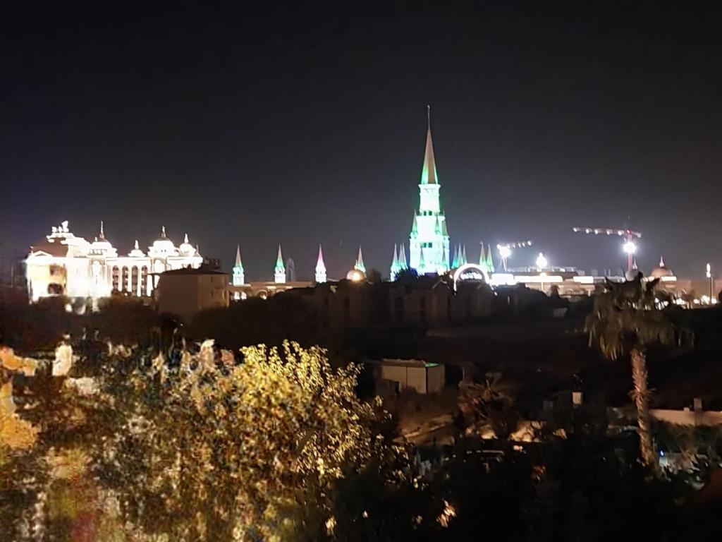 een stad 's nachts met een gebouw met groene lichten bij Villa belinay in Belek