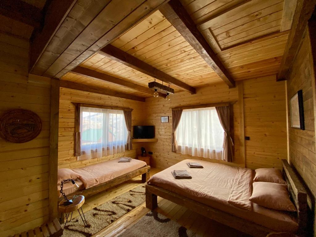 a room with two beds in a log cabin at Mountain Star House in Mojkovac