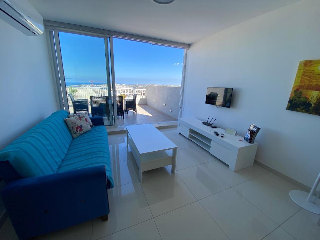 a living room with a couch and a table at Sunshine Apartments Mellieha - modern two bedroom penthouse with terrace in Mellieħa