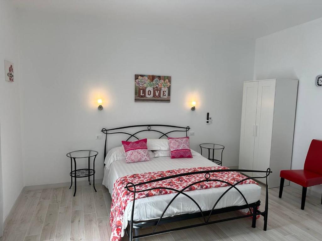 奧爾比亞的住宿－Blessed House Rooms，一间卧室配有带粉红色枕头和红色椅子的床