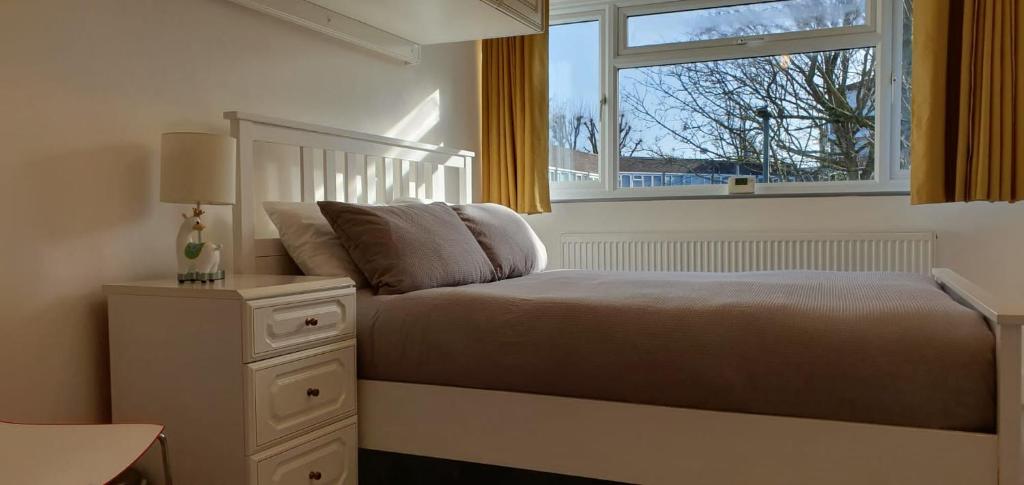 a bedroom with a bed and a window at LONDON EXPERIENCE in Eltham