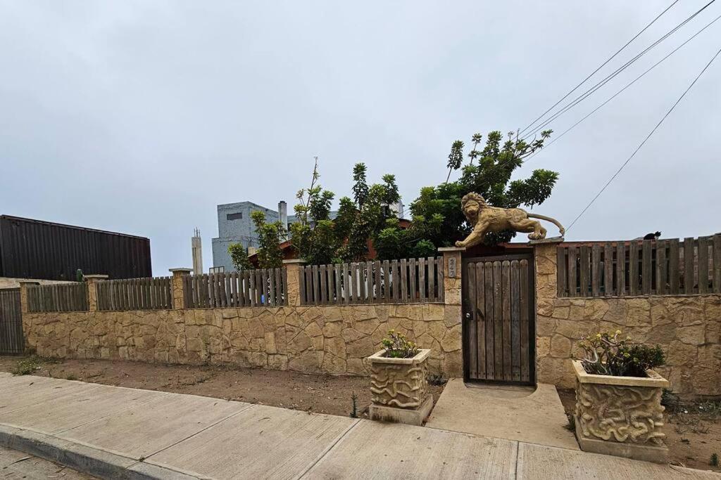 a statue of a lion on top of a stone fence at Amplia Casa a 4 cuadras de playa in Los Vilos