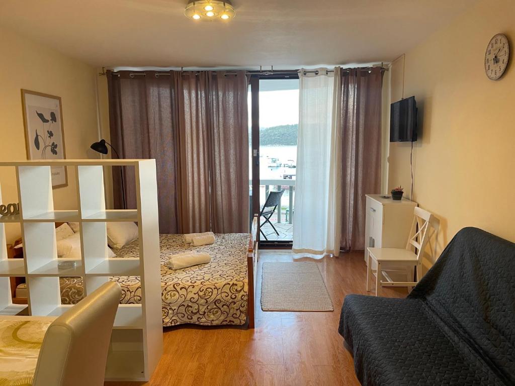 a bedroom with a bed and a room with a balcony at APARTMENTS Ana by the SEA in Lumbarda