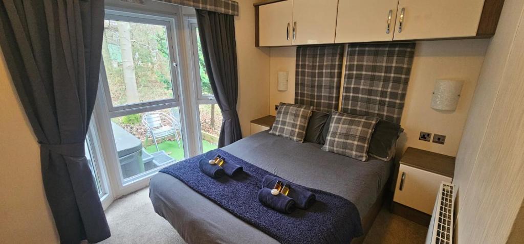 um quarto com uma cama e uma grande janela em Jax Retreat hot tub and free golf em Felton