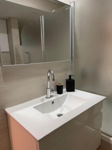 a bathroom with a white sink and a mirror at Petit Paradis au cœur de Jérusalem in Jerusalem