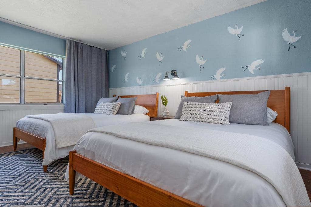 two beds in a bedroom with blue walls at Suwannee Gables in Old Town
