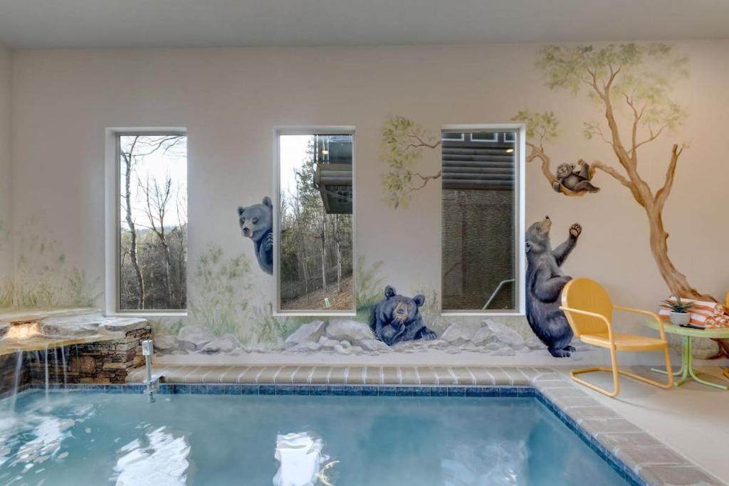 Habitación con piscina con osos en la pared en Newly built sleeps 10 Indoor pool & game rm, en Pigeon Forge