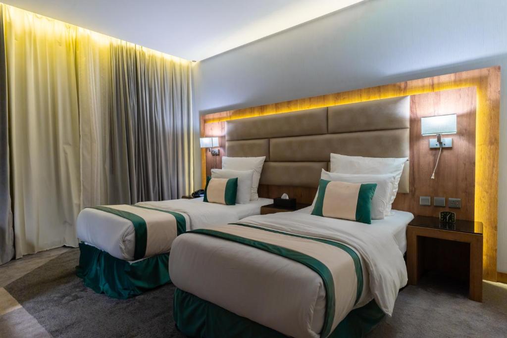 ein Hotelzimmer mit 2 Betten in einem Zimmer in der Unterkunft Rasia Hotel Jeddah in Dschidda