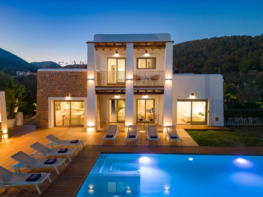 a villa with a swimming pool in front of a house at Villa in Ibiza Town sleeps 10 - Ses Llaneres in Ibiza Town