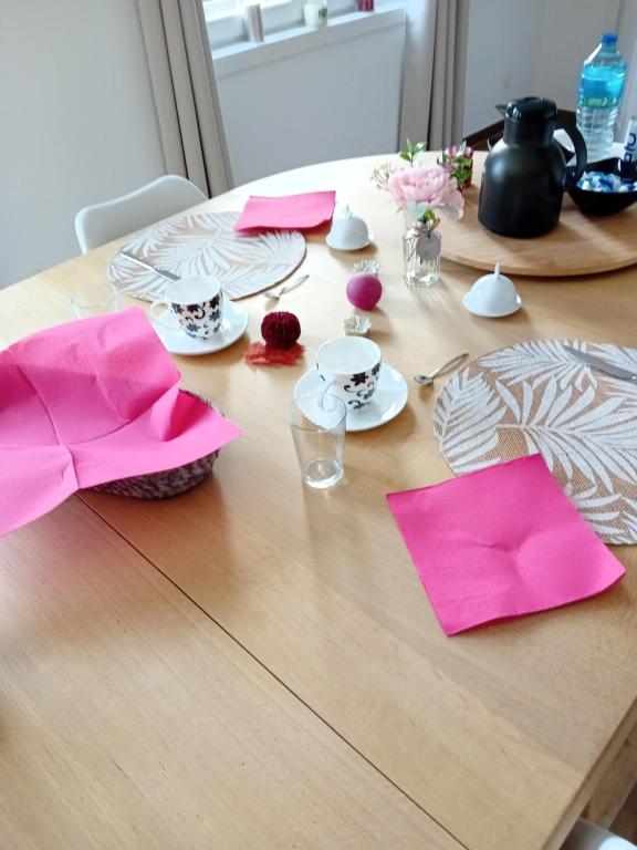 a wooden table with pink napkins on top of it at Ama&#39;s Sweet home in Saint-Hubert