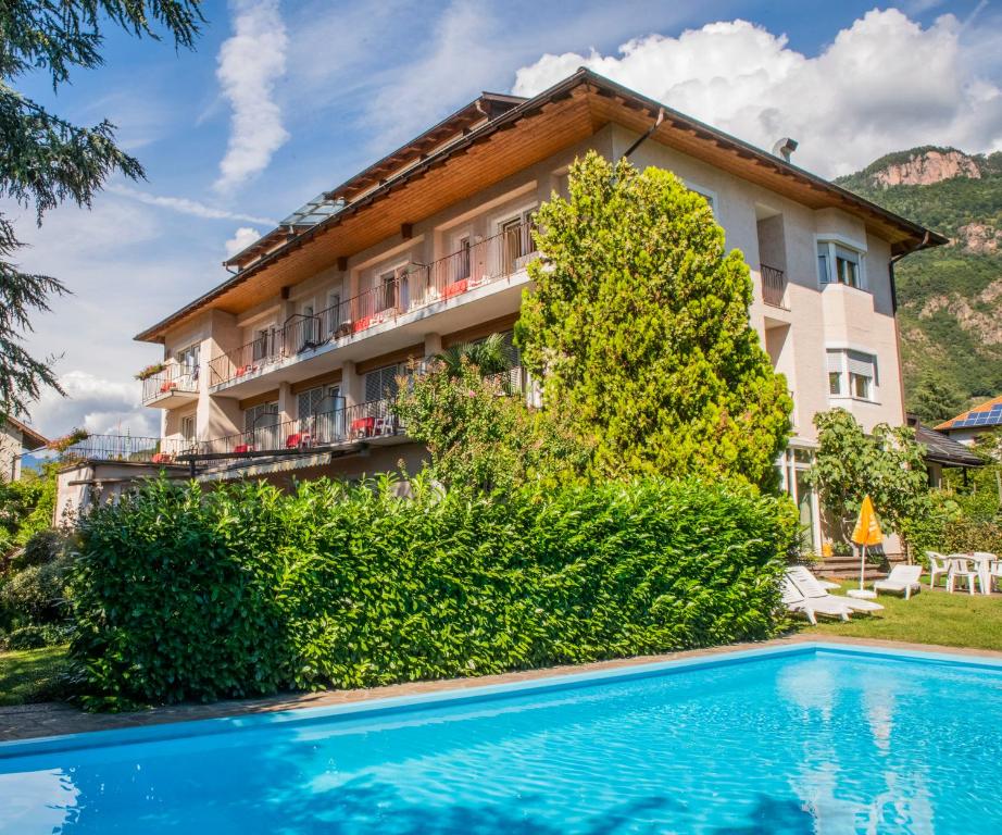 un hôtel avec une piscine en face d'un bâtiment dans l'établissement Weingarten Terlan - Rooms & Breakfast, à Terlano