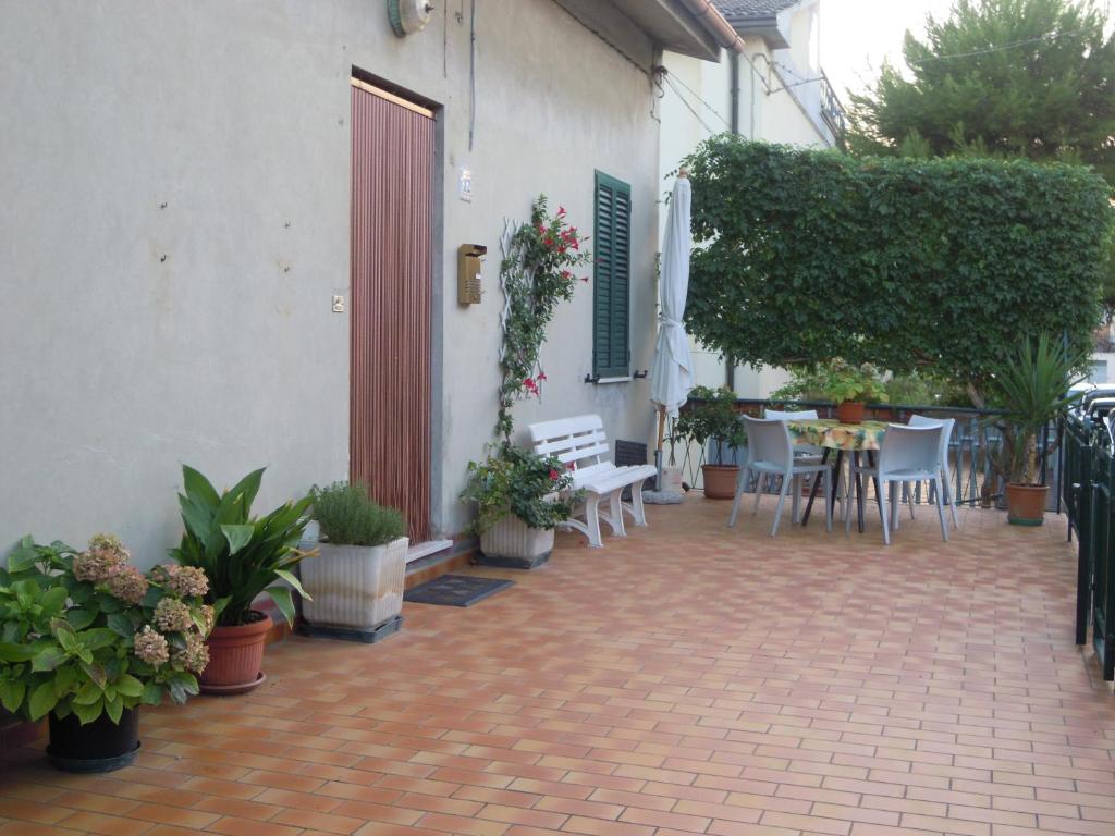 een patio met een tafel, stoelen en planten bij Le Fornaci in Castelfidardo