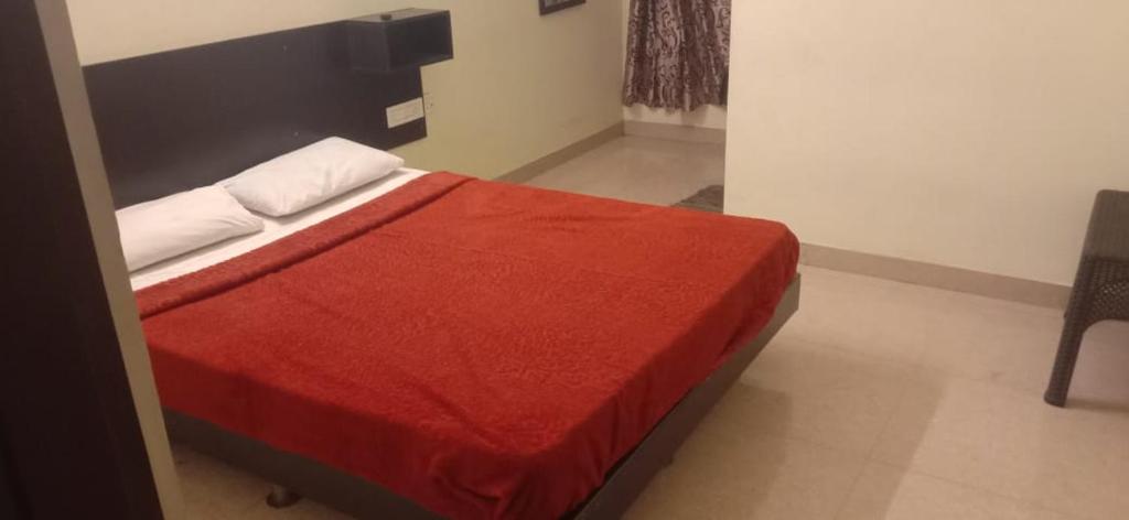 1 dormitorio con 1 cama con manta roja en The Grand Stays codissia, en Coimbatore