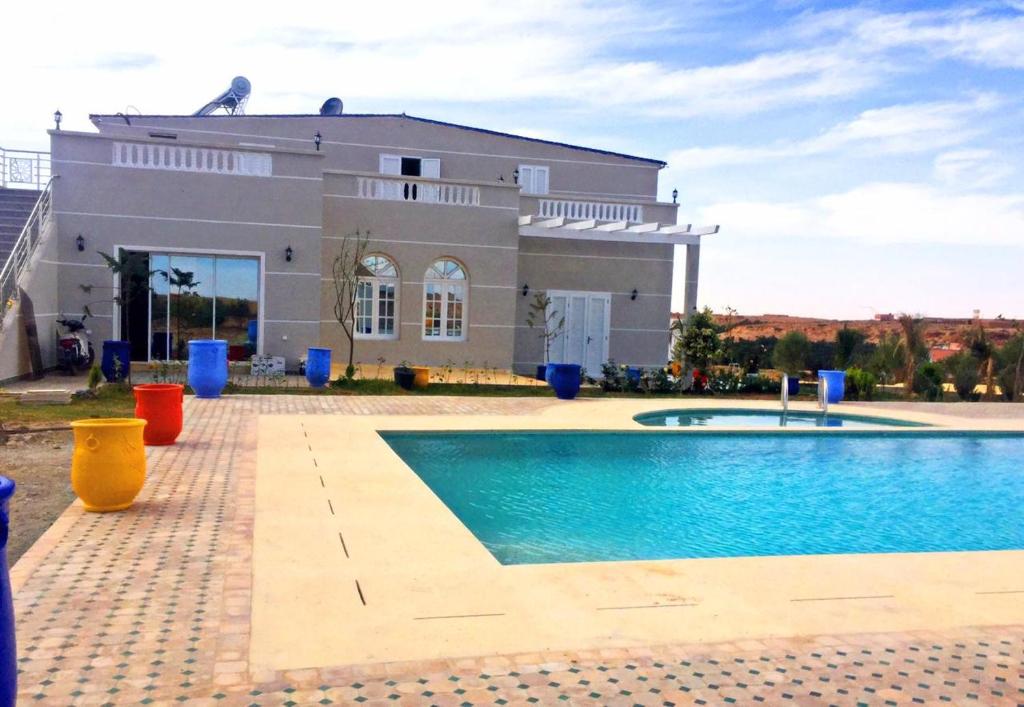 ein Haus mit einem Pool vor einem Haus in der Unterkunft Urti Villa in Nzala