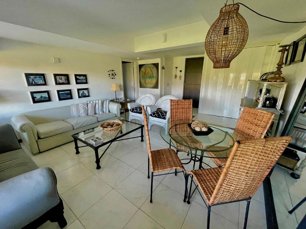 uma sala de estar com um sofá, uma mesa e cadeiras em Esturion de Montoya - La Barra - Punta del Este - 4 pasajeros em Punta del Este
