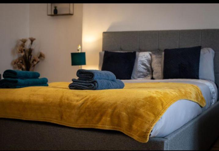 a bedroom with a large bed with a yellow blanket at Cozy Room @ Wallsend in Old Walker