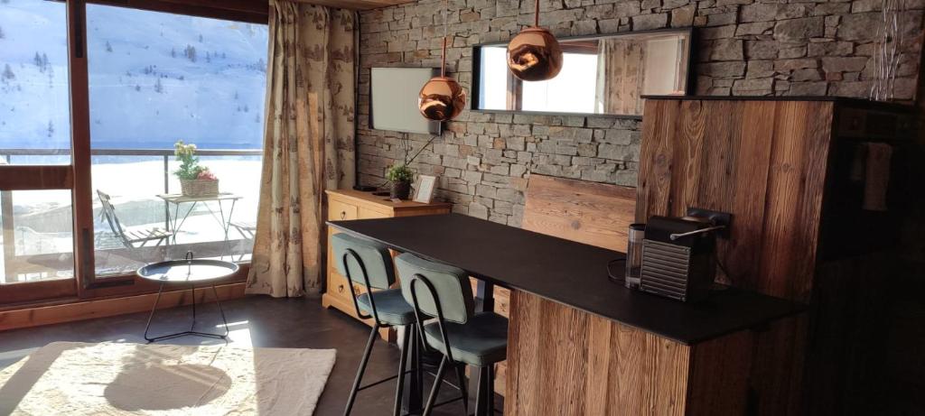 a kitchen with a counter and chairs in a room at Grands studios vue sur lac in Tignes