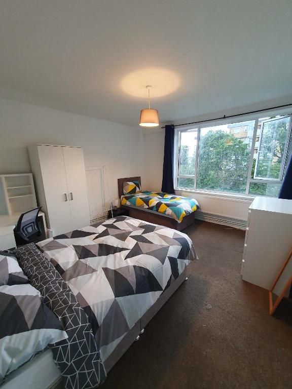 a bedroom with a bed and a window at Private rooms with shared facilities in Camden Town in London