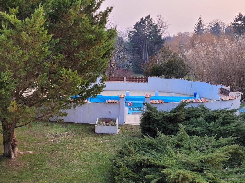 einen Zaun in einem Garten mit Bäumen davor in der Unterkunft Logis de La Garenne in Mortagne-sur-Gironde