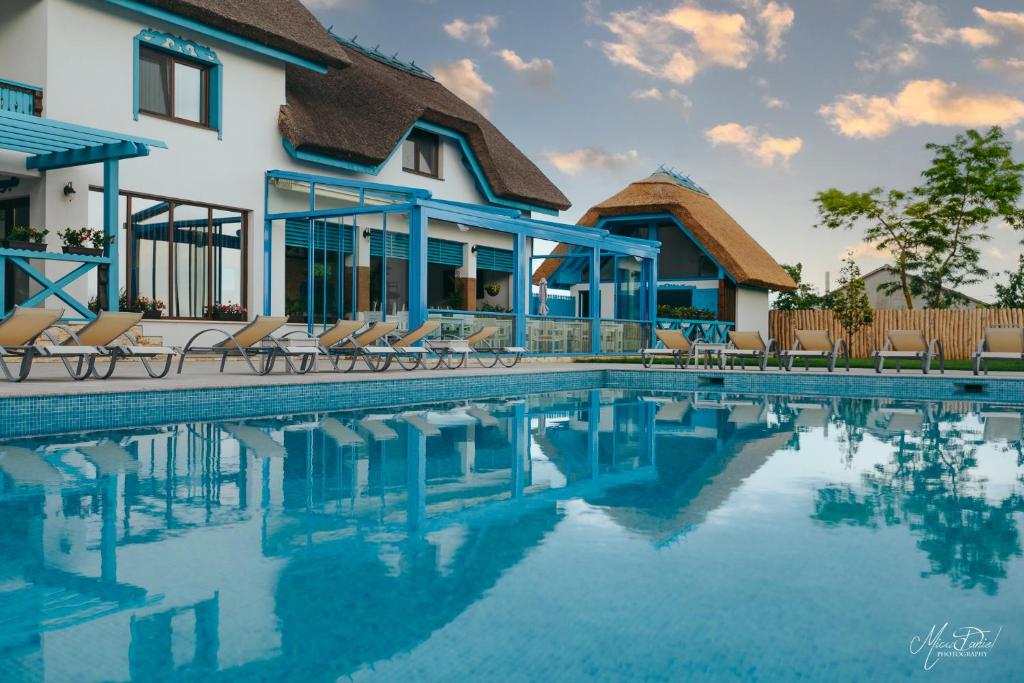 a swimming pool in front of a house at Pensiunea Briza Marii Jurilovca in Jurilovca