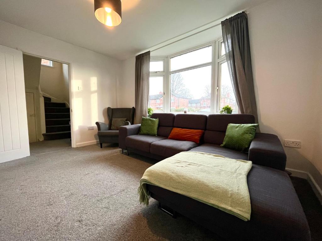uma sala de estar com um sofá e uma janela em Cosy 4-Bed House in Manchester em Manchester