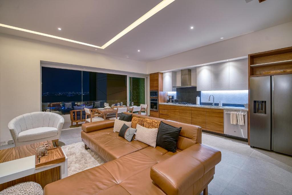 Il comprend un salon avec un canapé et une cuisine. dans l'établissement Luxurious Penthouse in Puerto Vallarta, à Puerto Vallarta
