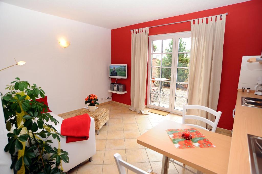 - une cuisine et une salle à manger avec des murs rouges et une table dans l'établissement KASTANIENHOF, à Burg