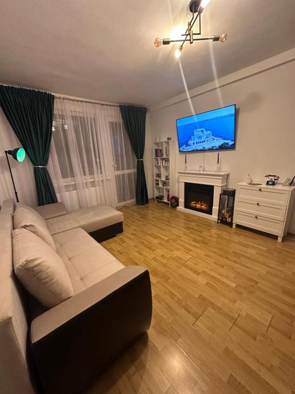 een woonkamer met een witte bank en een open haard bij Vintage Apartament in Constanţa