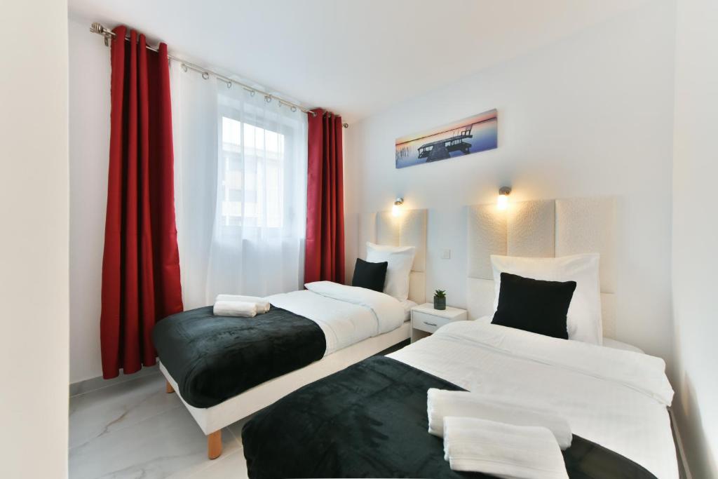 deux lits dans une chambre avec des rideaux rouges dans l'établissement Stylish 2 rooms in the heart of Cannes, à Cannes