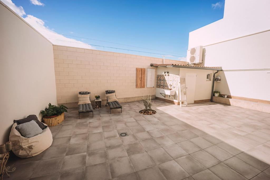 eine Terrasse mit 2 Stühlen und ein Gebäude in der Unterkunft Albergue Turístico LAbellaVILLA in Rincón de Soto