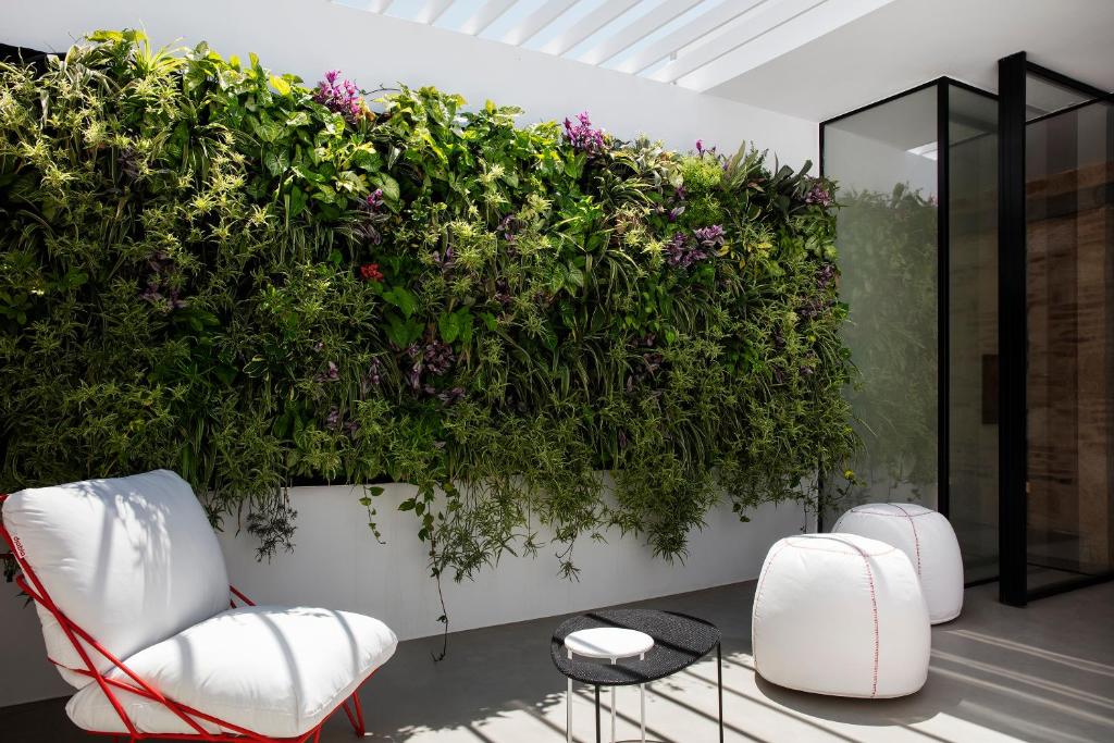 una pared con plantas y sillas en una habitación en Elorhouse in the charming neighborhood of KoumKapi, en La Canea
