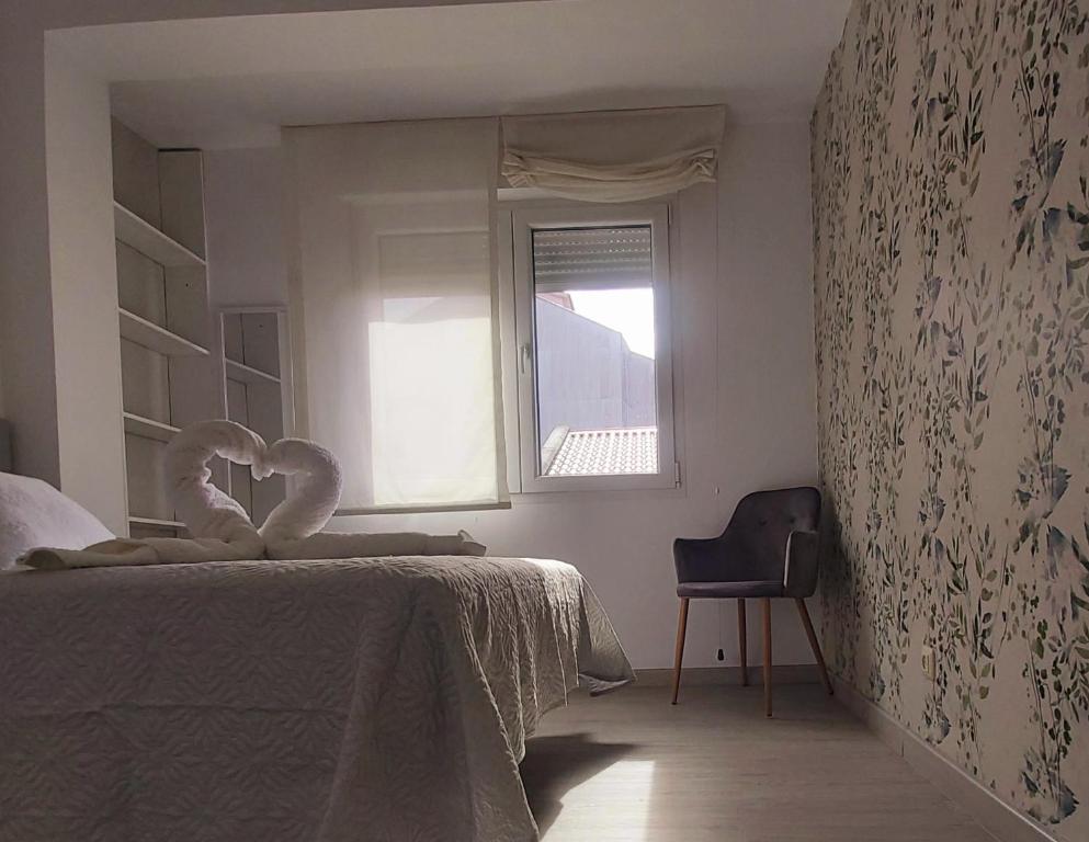 a bedroom with a bed and a window and a chair at Novama in O Grove