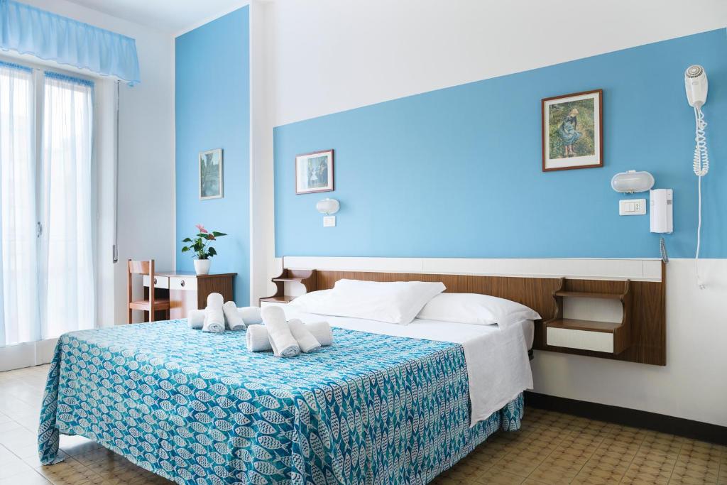 a blue bedroom with a bed with a blue wall at Hotel Cheri in Rimini